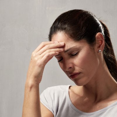 Una mujer con dolor de cabeza debido a problemas en la mandíbula